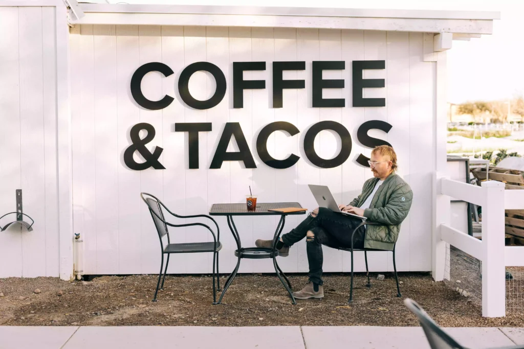 Me sitting at a coffee shop taking photos for an article about how to set goals and crush them